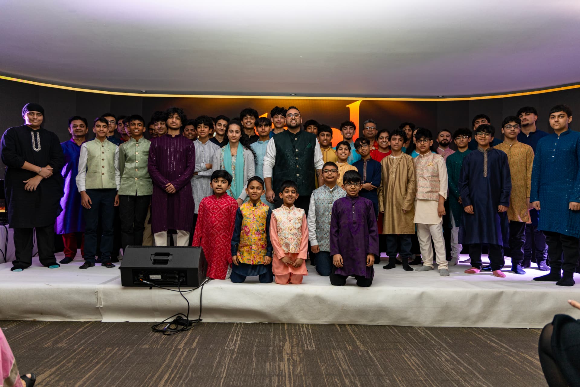 Sachin Khetani with a large group of Taal Music Academy students on stage at an academy showcase